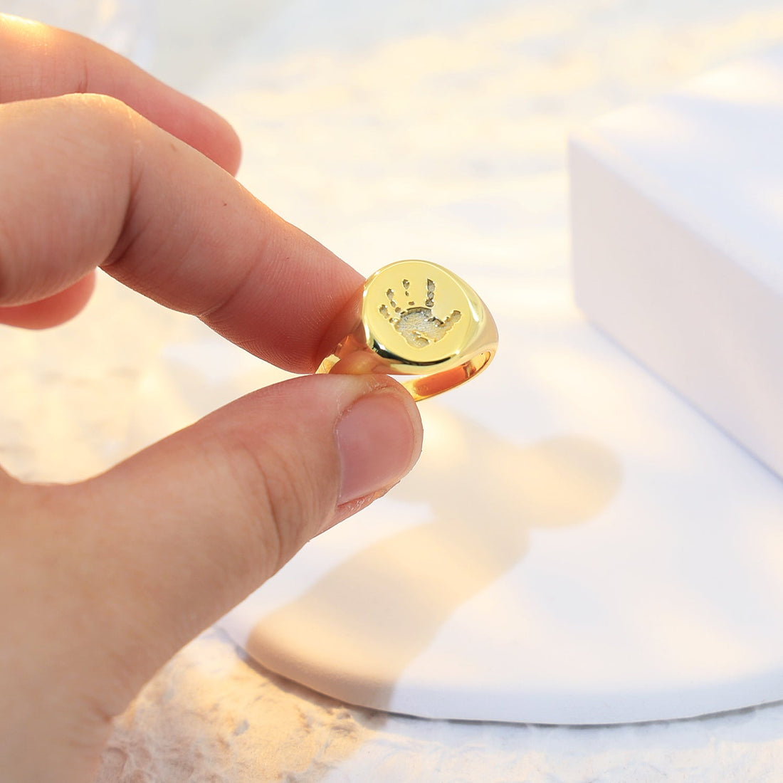 Custom gold ring with unique engraving of a baby handprint, quality craftsmanship