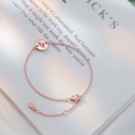 Rose-gold bracelet with engraved baby footprints — handcrafted keepsake jewelry by Chapters of Joy.