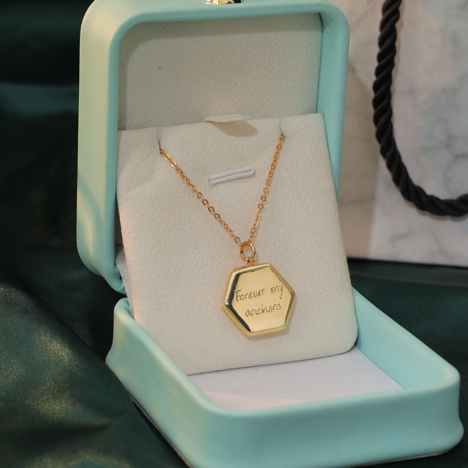 Engraved handwriting “Forever My Anchor” on gold locket — personalized keepsake jewelry.