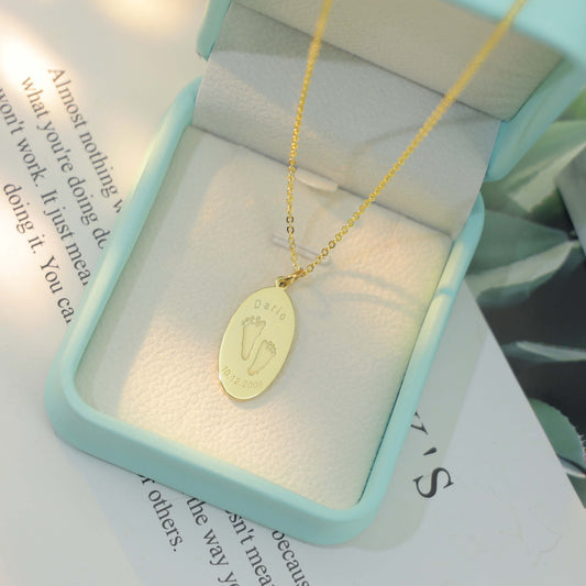 Oval Dario Necklace with engraved baby footprints, name, and birthdate – custom keepsake jewelry by Chapters of Joy.