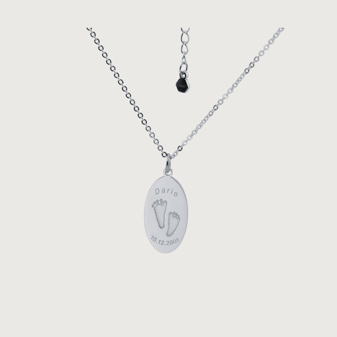 Oval Dario Necklace in sterling silver with engraved baby footprints, name, and birthdate – custom keepsake jewelry by Chapters of Joy.