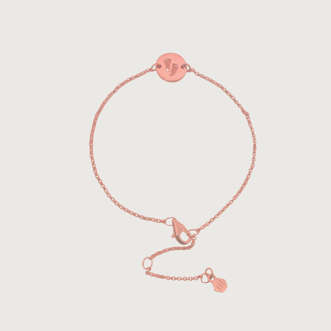 Custom bracelet engraved with footprints — sentimental rose-gold keepsake.