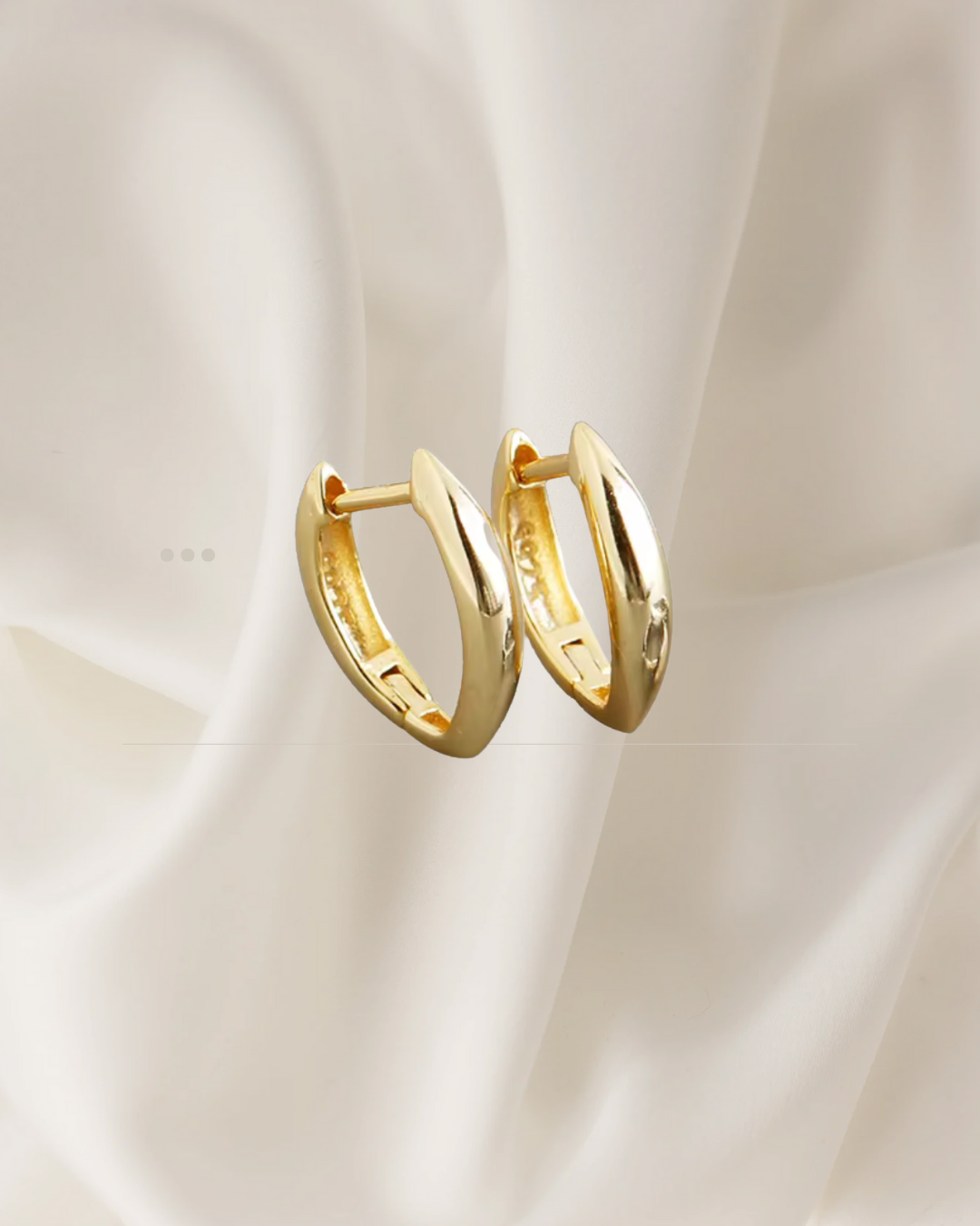 Elongated sculptural gold hoop earrings with soft curves — Auri Hoops by Chapters of Joy.