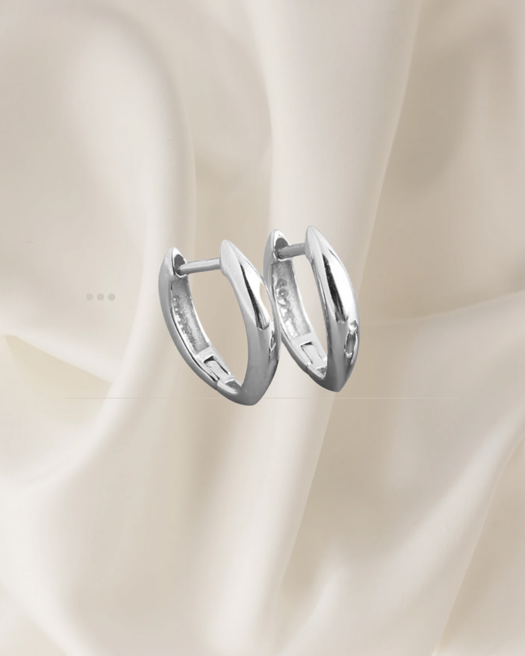 Elongated sculptural silver hoop earrings with soft curves — Auri Hoops by Chapters of Joy.
