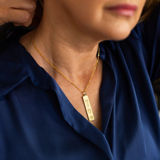 Woman wearing The Dila Pendant engraved with handprint, footprint and paw print for lasting memory