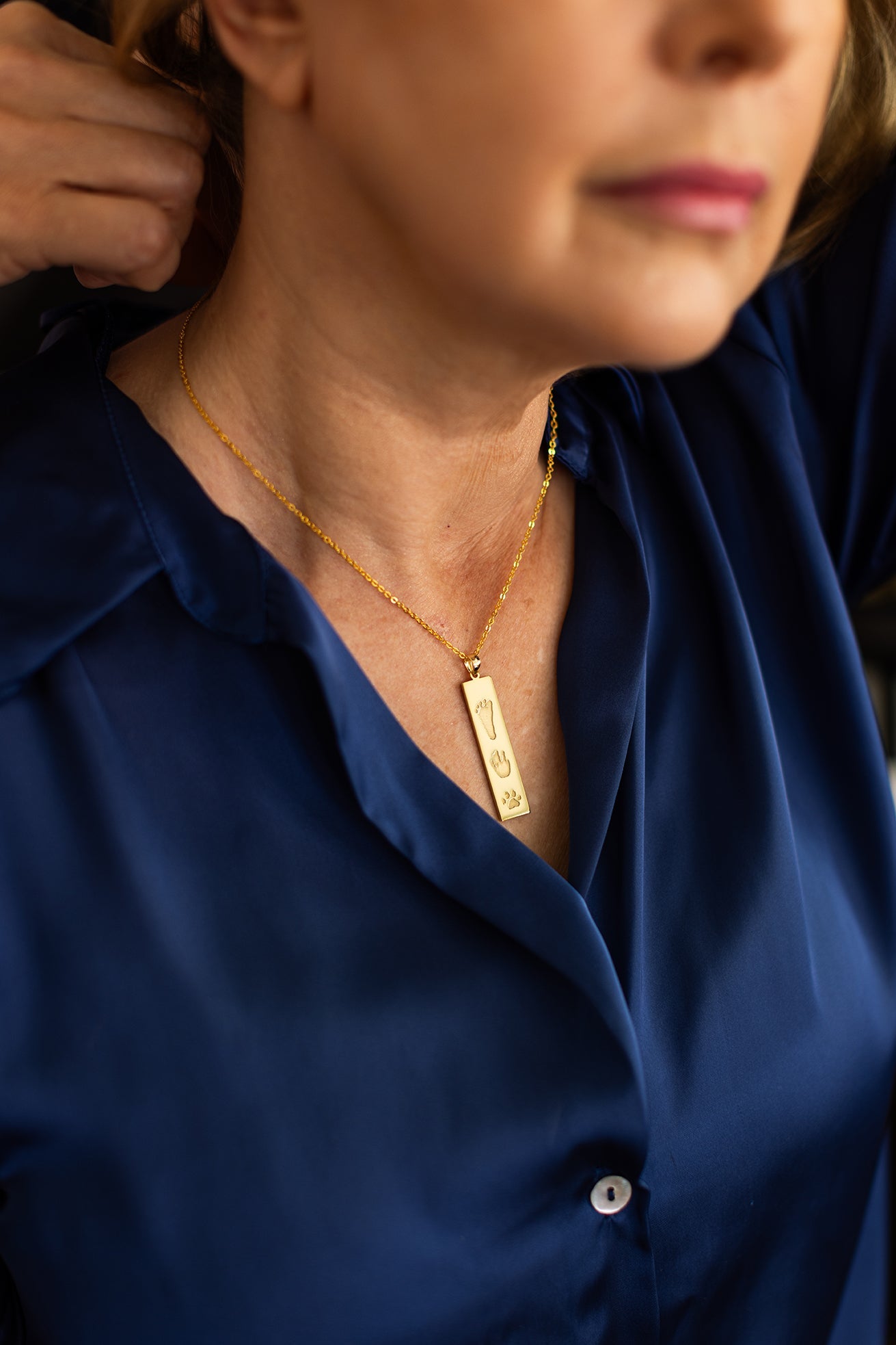 Woman wearing The Dila Pendant engraved with handprint, footprint and pawprint for lasting memory
