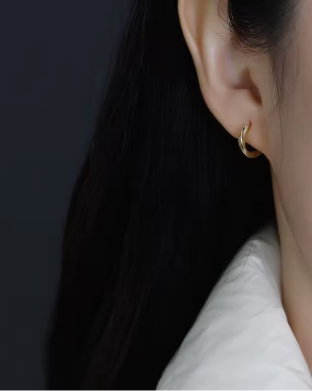 Sculpted gold  hoop earrings with gentle flowing curves  worn on the ear— Wavelet Hoops by Chapters of Joy.