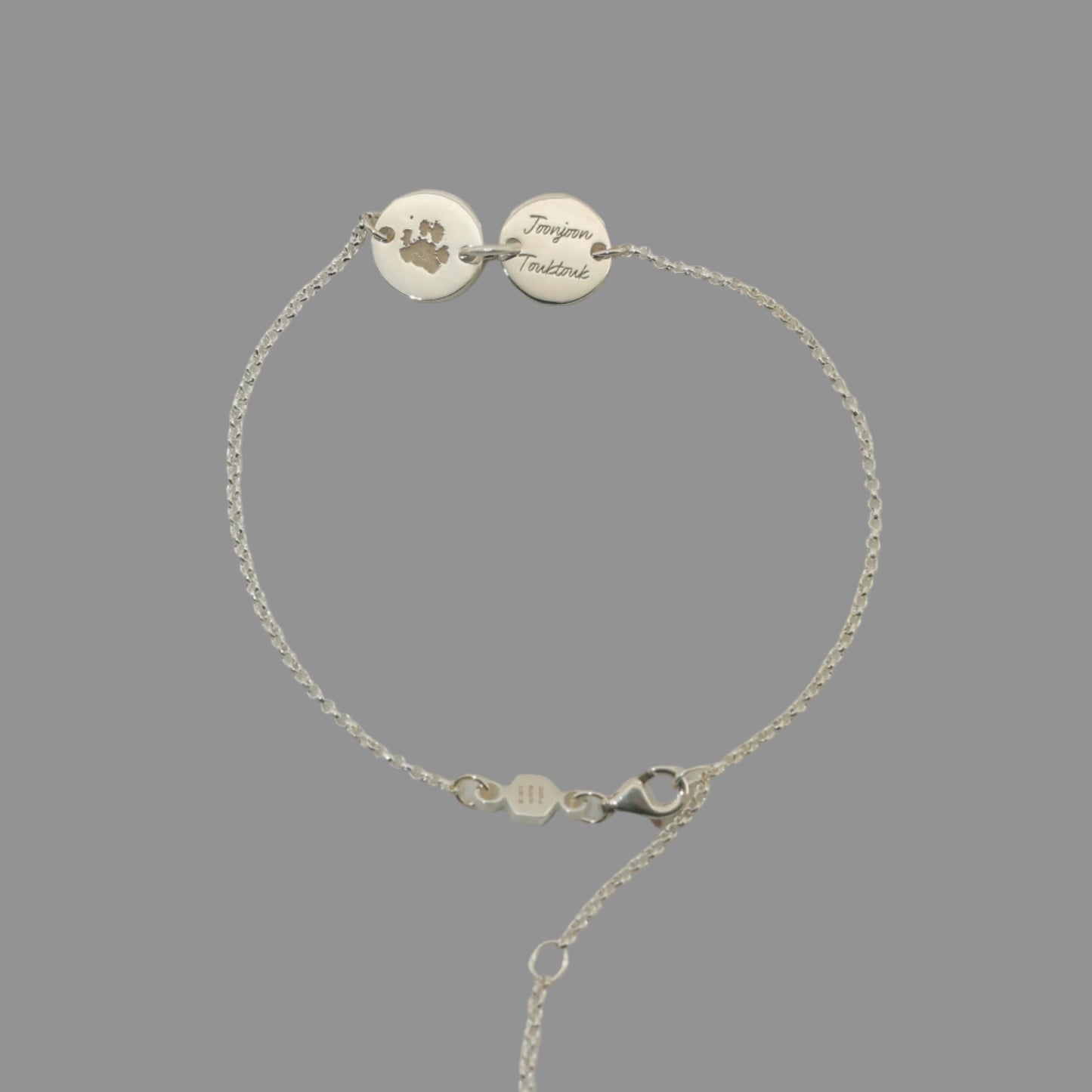 Sterling silver bracelet engraved with pet paw print and name. great custom keepsake jewelry from Chapters of Joy.