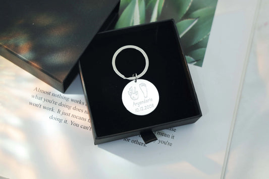Sterling silver round Tina Tag engraved with a child’s handprint and footprint, name, and birthdate symbolizing love and connection.