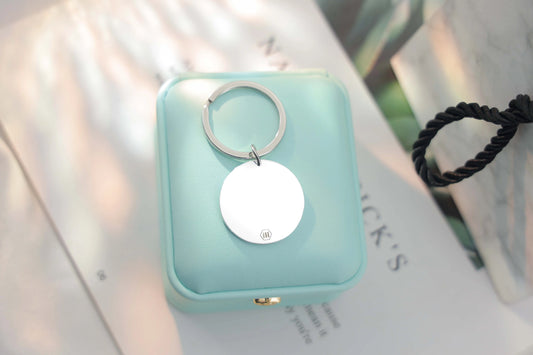 Sterling silver round Tina Tag engraved with a child’s handprint and footprint, name, and birthdate symbolizing love and connection.