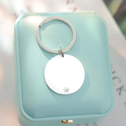 Sterling silver round Tina Tag engraved with a child’s handprint and footprint, name, and birthdate symbolizing love and connection.