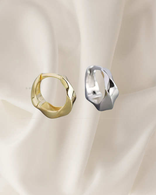 Twisted sterling silver and gold hoop earrings reflecting light and movement — Lira Hoops by Chapters of Joy.