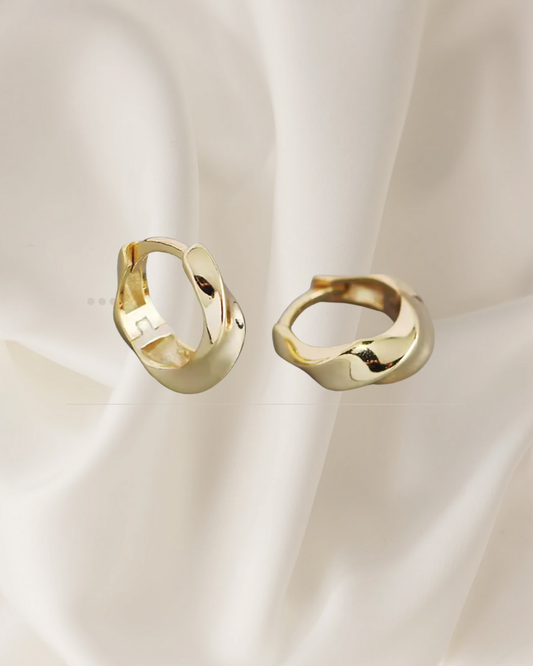 Twisted sterling silver and gold hoop earrings reflecting light and movement — Lira Hoops by Chapters of Joy.