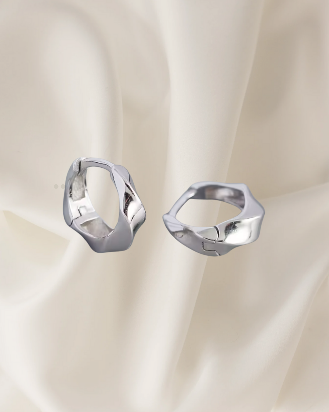Twisted sterling silver hoop earrings reflecting light and movement — Lira Hoops by Chapters of Joy.