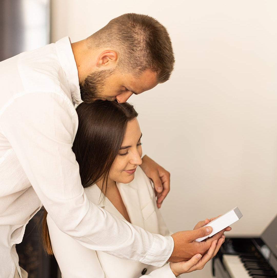 Man surprising a woman with a jewelry gift, romantic moment of giving personalized jewelry.