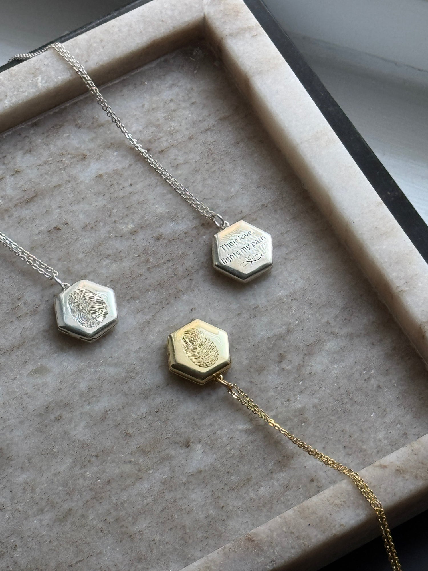 honeycomb lockets with fingerprint, handwriting, double fingerprint engraved on them, by chapters of Joy