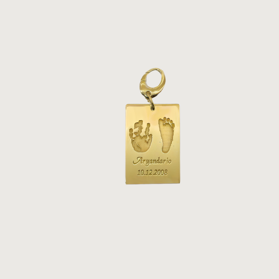 Gold plated Ema Tag engraved with a child’s hand and footprint, name and birthdate attached to a keychain, symbolizing love and connection.