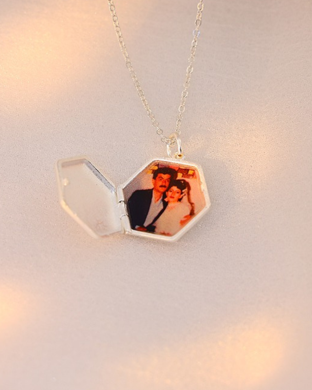 Maelle hexagon locket necklace opened to reveal a photo inside, custom engraved keepsake jewelry.