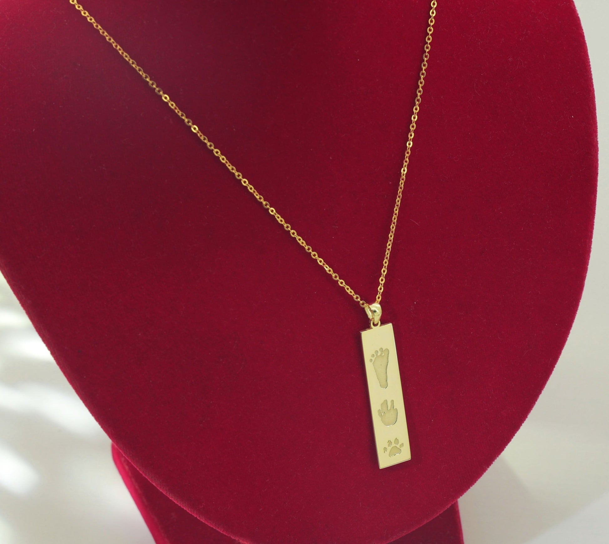 Flat lay of The Dila Pendant showcasing double-sided engraving options