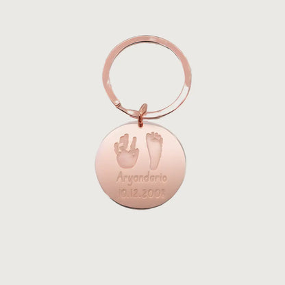 Rose Gold Plated Sterling silver round Tina Tag engraved with a child’s handprint and footprint, name, and birthdate 