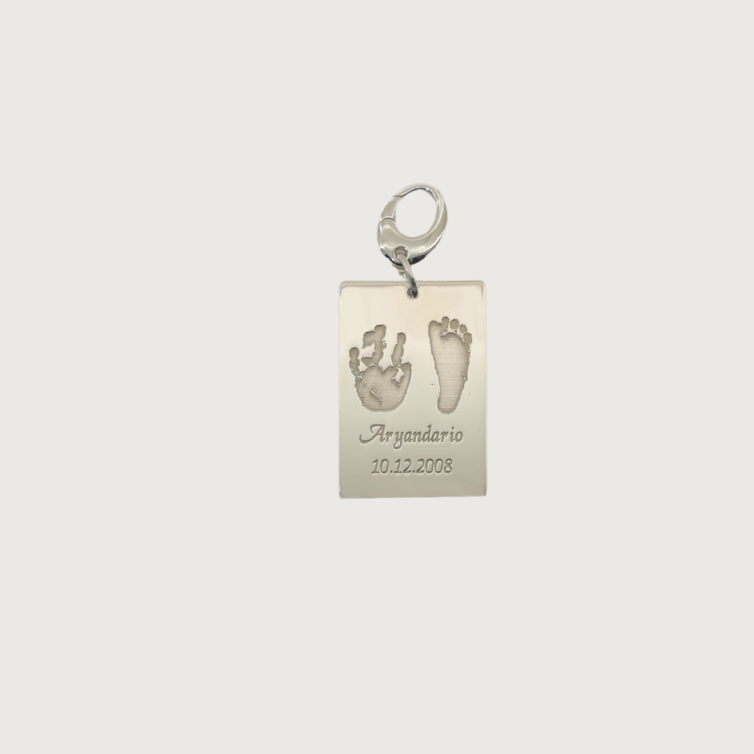 Sterling SIlver plated Ema Tag engraved with a child’s hand and footprint, name and birthdate attached to a keychain, symbolizing love and connection.