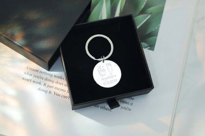 Sterling silver round Tina Tag engraved with a child’s handprint and footprint, name, and birthdate symbolizing love and connection.
