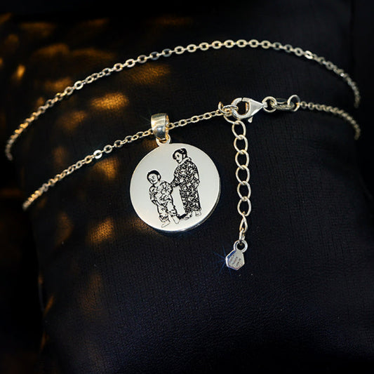 Silver necklace with a pendant featuring picture of two kids from a picture engraved