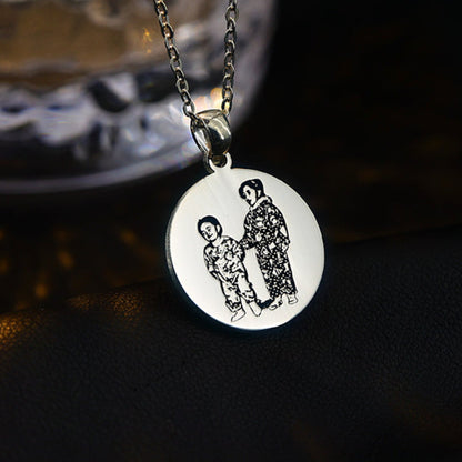 Silver necklace with a round pendant featuring engraved images on a dark background