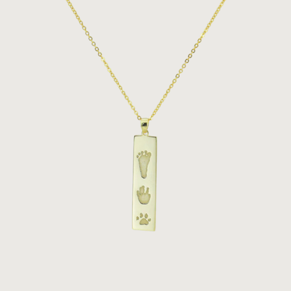 Flat lay of The Dila Pendant showcasing double-sided engraving options
