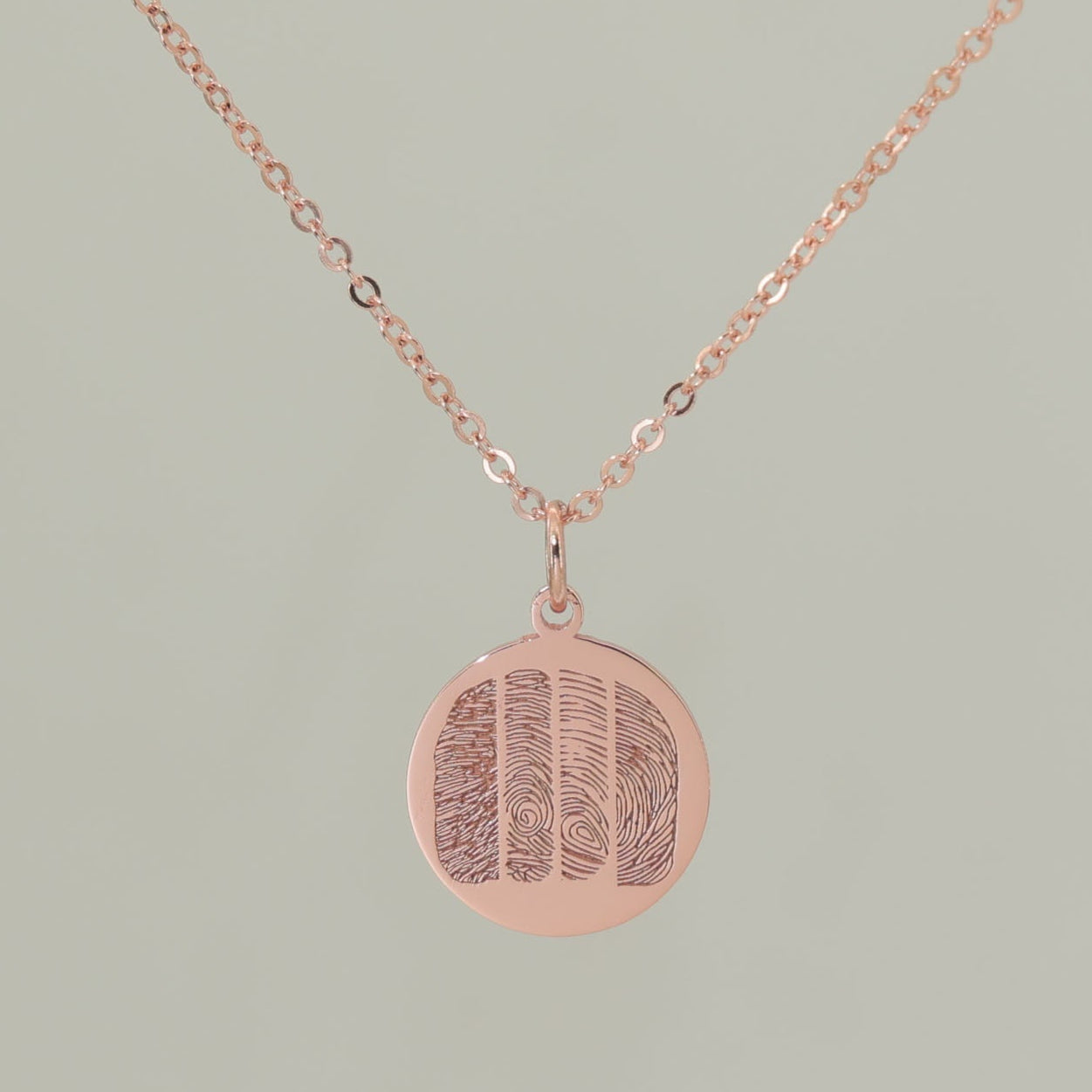 Sterling silver, rose gold plated pendant engraved with four unique fingerprints.