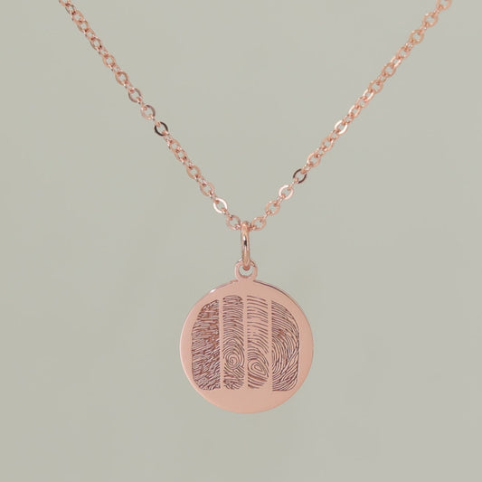 Sterling silver, rose gold plated pendant engraved with four unique fingerprints.