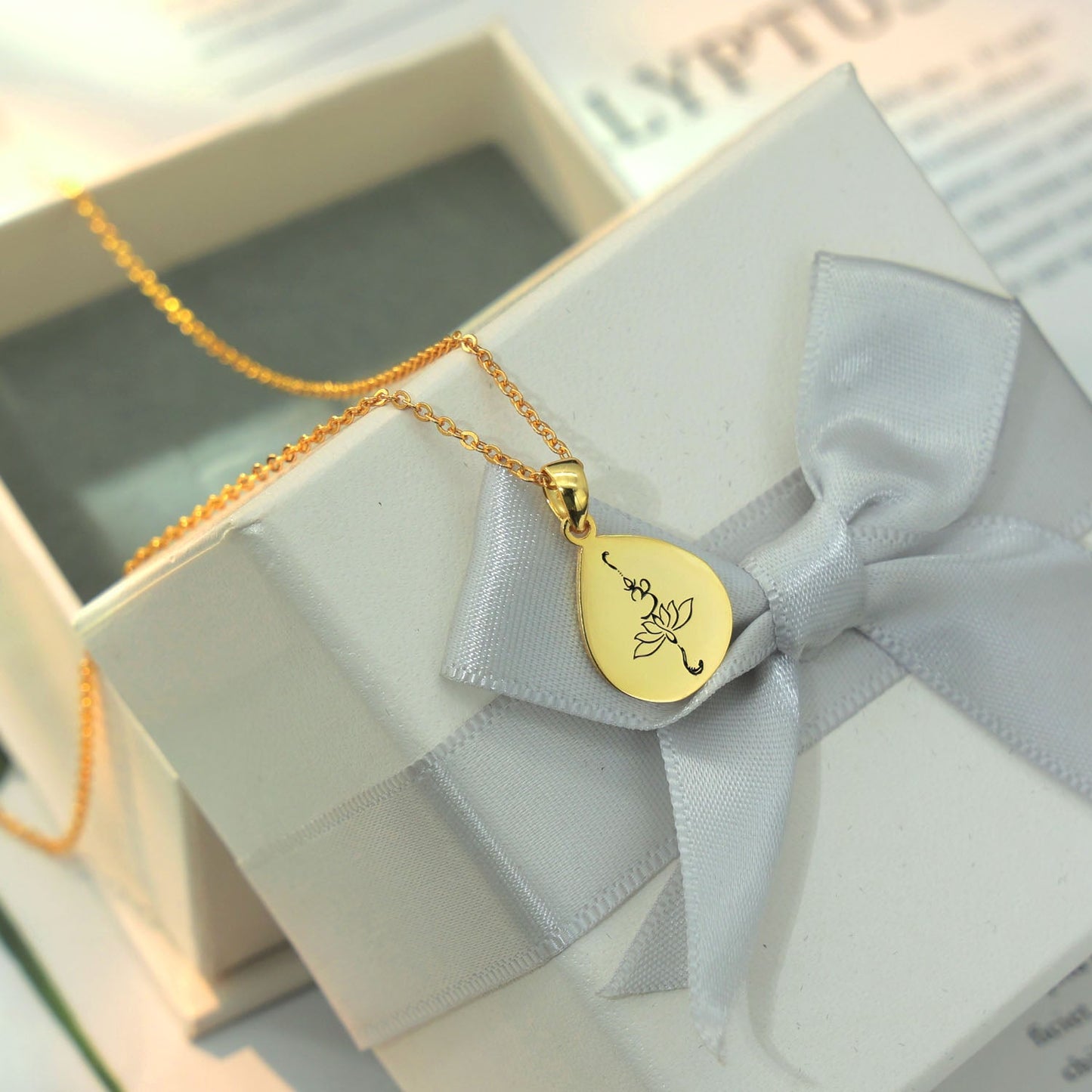 Rose drop shape  pendant is sterling silver and gold plated with OM and lotus engraving in black