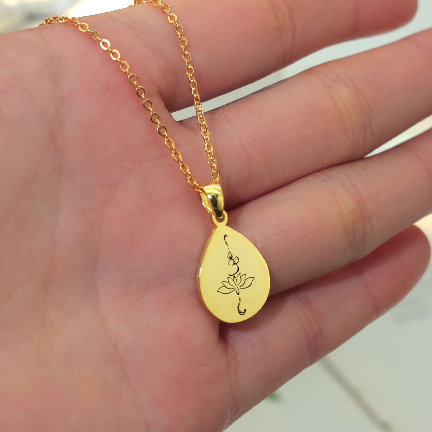 Rose tear drop shape  pendant is sterling silver and gold plated with OM and lotus engraving in black