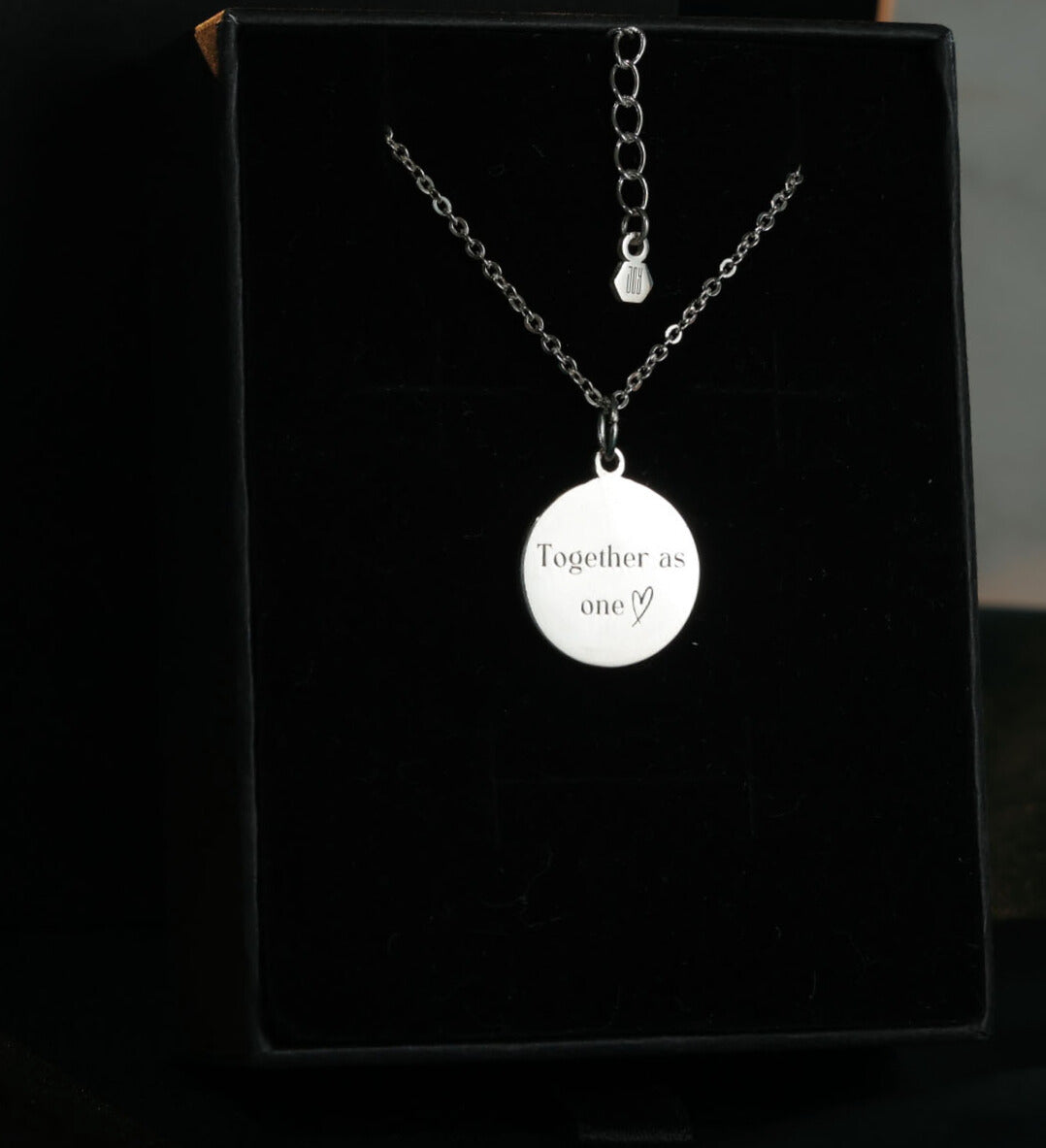Back view of round sterling silver pendant engraved with custom message