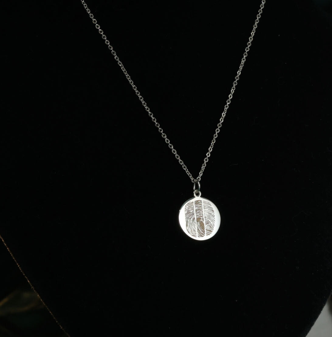 Personalized fingerprint necklace in sterling silver on black background
