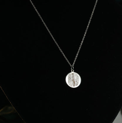 Personalized fingerprint necklace in sterling silver on black background