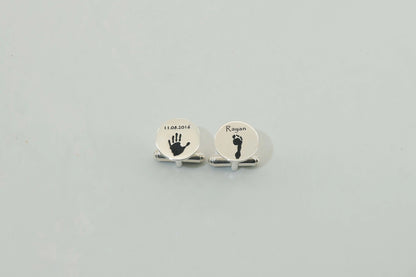 Round silver cufflinks engraved with a baby handprint and footprint — personalized cufflinks by Chapters of Joy.