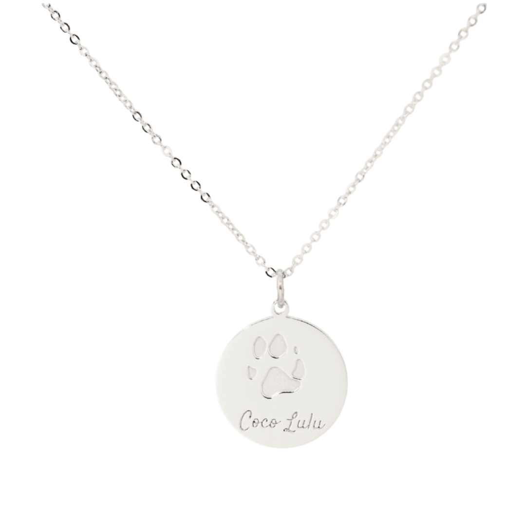 Silver paw print pendant engraved with a pet’s name, custom memorial necklace from Chapters of Joy.